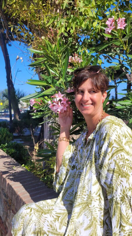 Monika Klumpp im Urlaub vor Blumen - Heilpraktikerin